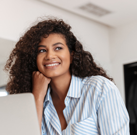 femme pensive sourit ordiinateur