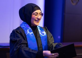 Jeune femme habillée en noir à sa remise de diplôme en ressources humaines