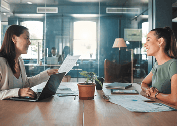 Une manager et son employée Deux femmes discutent dans un bureau avec une vitre derrière