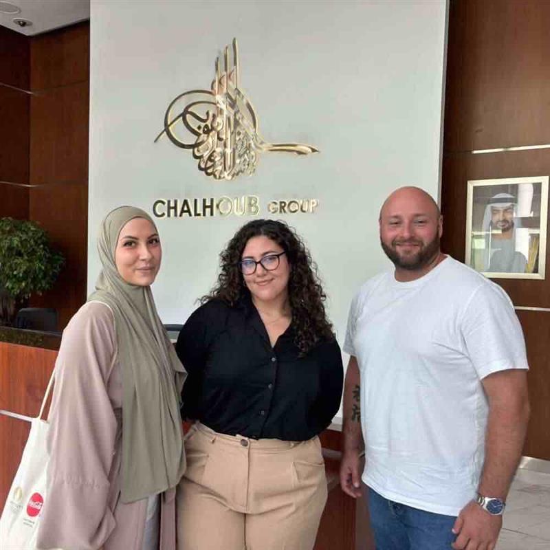 Etudiants gagnants du projet Dubai de l'ESGRH Un homme et deux femmes posent face à la caméra dans le hall d'une entreprise à Dubai