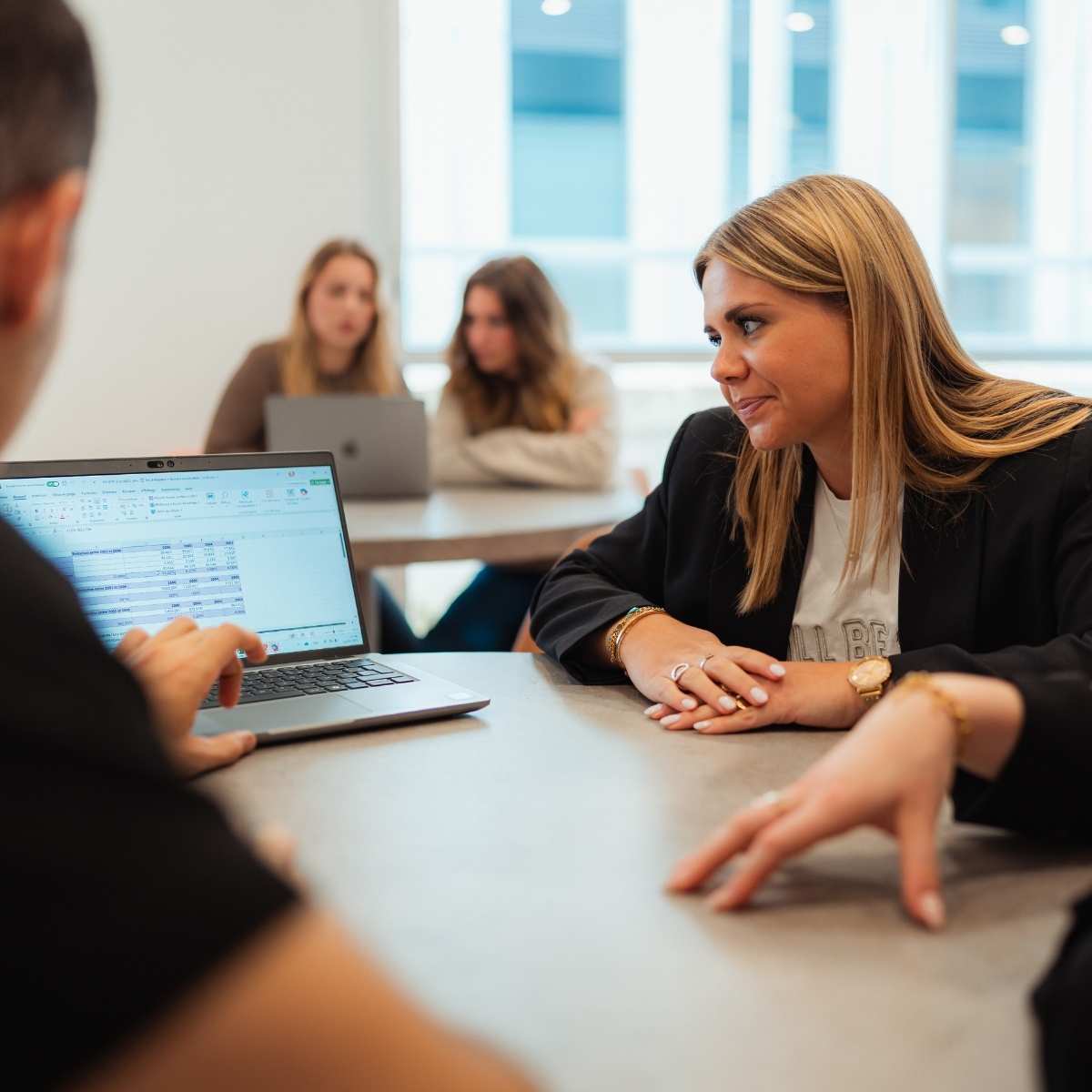 Des élèves sont en projet de groupes, deux étudiantes sont en arrières plans et trois étudiants au premier plan