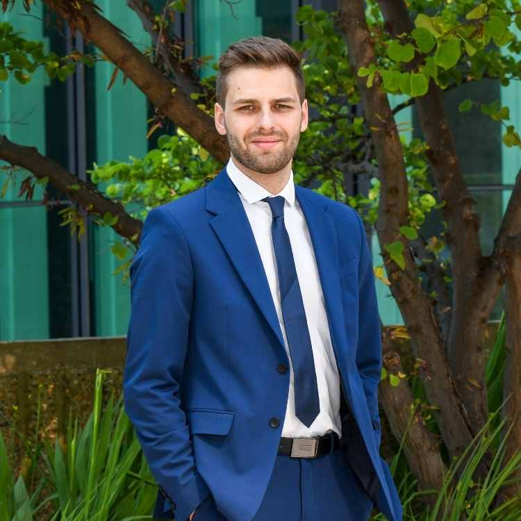 Ancien étudiant Jeune homme blond en costume dehors